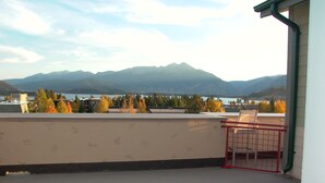 A balcony with a view of mountains and a lake.