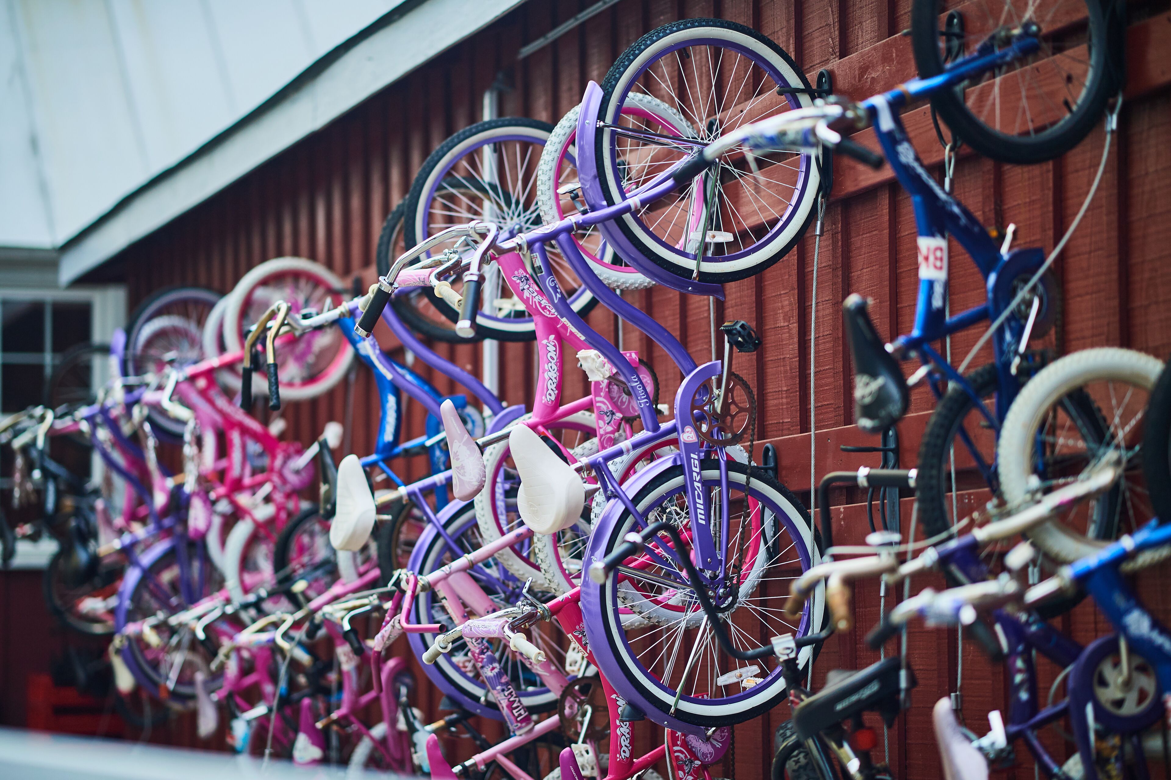 Bicycles parked against a wooden wall.