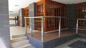 A staircase leading to a wooden door with glass panels, surrounded by dark and light tiled walls. - Front line with sea views garage + free wifi (Zarauz)