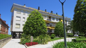 A modern building with a balcony, surrounded by well-maintained greenery and a clear sky. - Front line with sea views garage + free wifi (Zarauz)