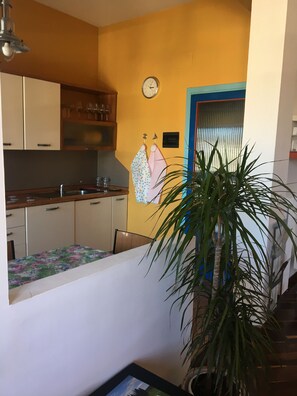 A kitchen with wooden cabinets, a sink, and a clock on the wall.