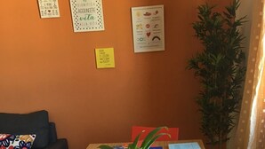 A room with a wooden table, a sofa, and a potted plant. - Casa Arcobaleno, an experience to try! (Firenze)