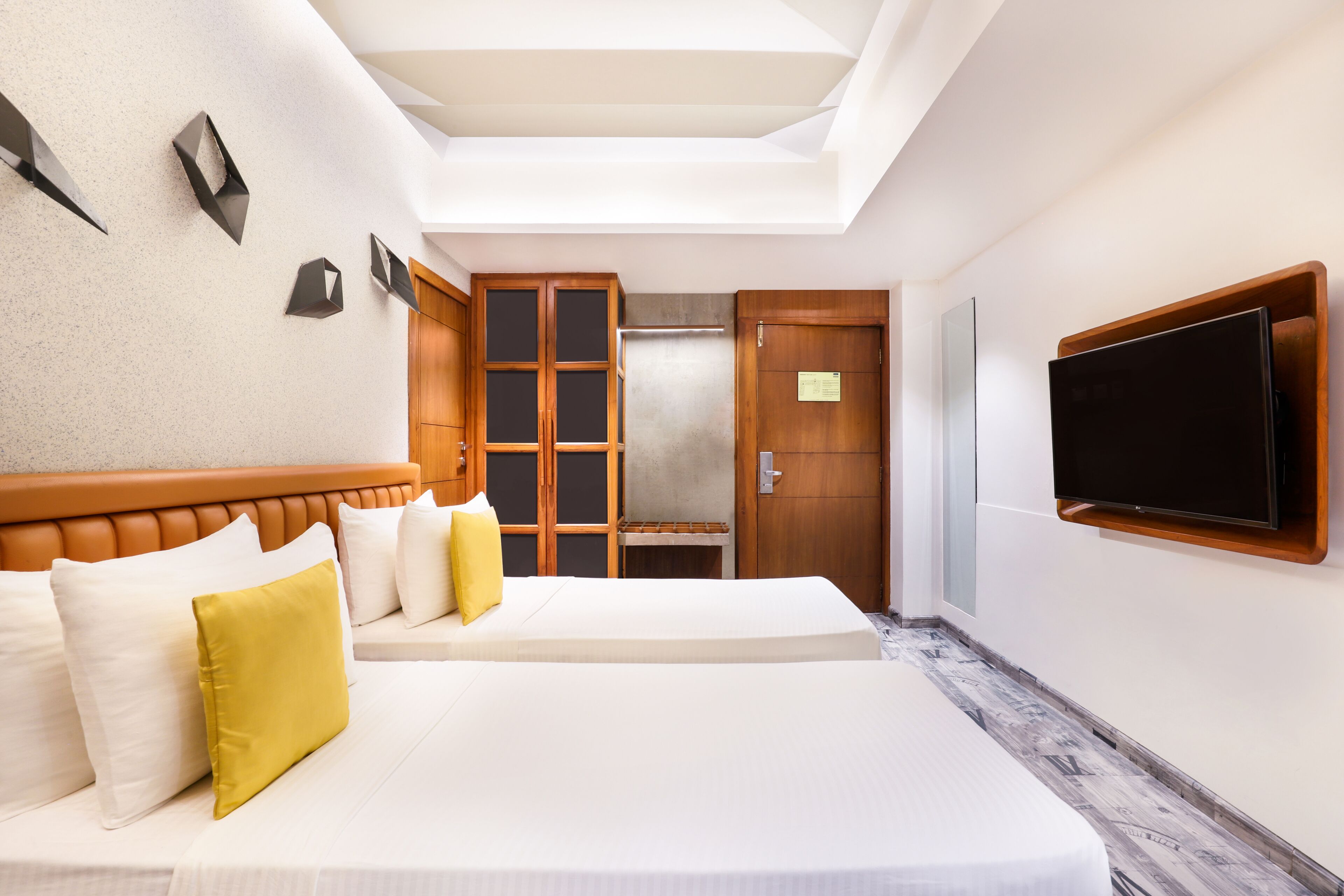 A hotel room with a large bed, a television mounted on the wall, and a skylight above.
