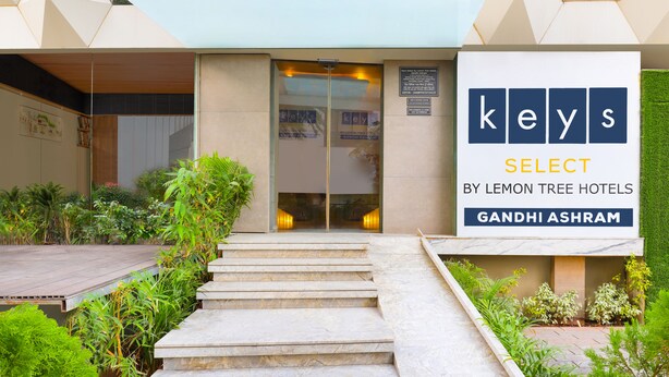 Een hotelentree met een bord waarop staat: keys SELECT BY LEMON TREE HOTELS GANDHI ASHRAM.