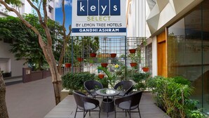 Een hotelschild, een terras en groen.