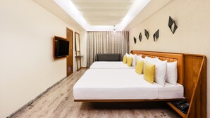 Een hotelkamer met een groot bed, een televisie en een plafondlamp.