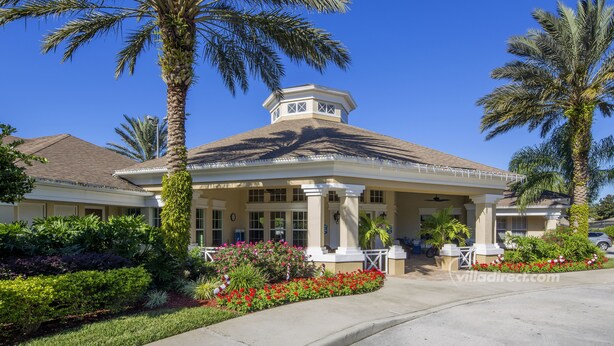 A hotel with a covered outdoor area, palm trees, and a well-maintained garden. - Our Quiet Retreat by VillaDirect (Kissimmee)