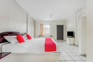 A hotel room with a bed, a TV, and a door. - OYO Hotel Jaguar (Cancun)