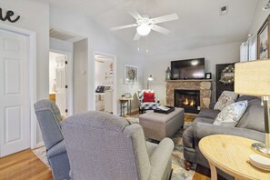 A living room with a fireplace, a ceiling fan, and a television. - Welcome to “Relax Inn” Retreat at Lake Cumberland – A Perfect Cabin Escape (Burnside)