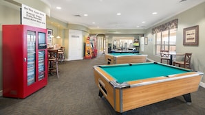 A pool table area with a red rental equipment station, a sign for on-the-spot DVD rentals, and a glimpse of a pool table in the background. - Summer Settings by VillaDirect (Kissimmee)