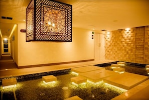 Ein Wellnessbereich mit Wasserspiel, Dekowand und Rezeption.