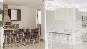 Una cocina moderna con barra, que incluye una encimera y taburetes.
