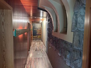 A hallway with wooden paneling, a stone wall, and a patterned floor. - Group house for up to 30 people in the Southern Harz Mountains - Group house for up to 30 people (Bad Sachsa)