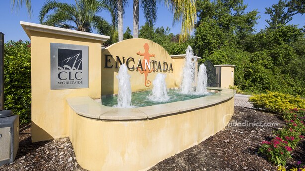 A sign for Encantada with a water feature in front. - Encantada Rose by VillaDirect (Kissimmee)