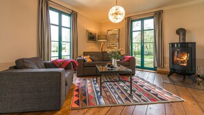 Una sala de estar acogedora con sofá, sillón, mesa de centro y chimenea.