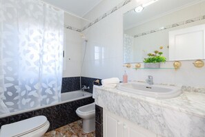Ein Badezimmer mit Badewanne, Toilette und Waschbecken.