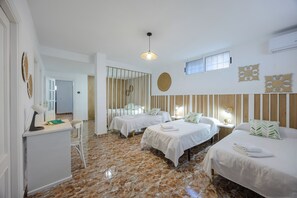 Ein Hotelzimmer mit zwei Betten, einem Schreibtisch, einem Stuhl, einem Spiegel und einer Deckenleuchte.