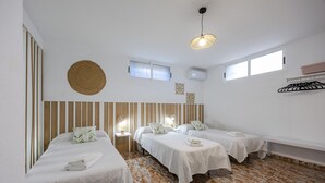 A hotel room with two beds, a round woven wall hanging, a ceiling light, and a window. - Fidalsa Grand White House (Mutxamel / Muchamiel)