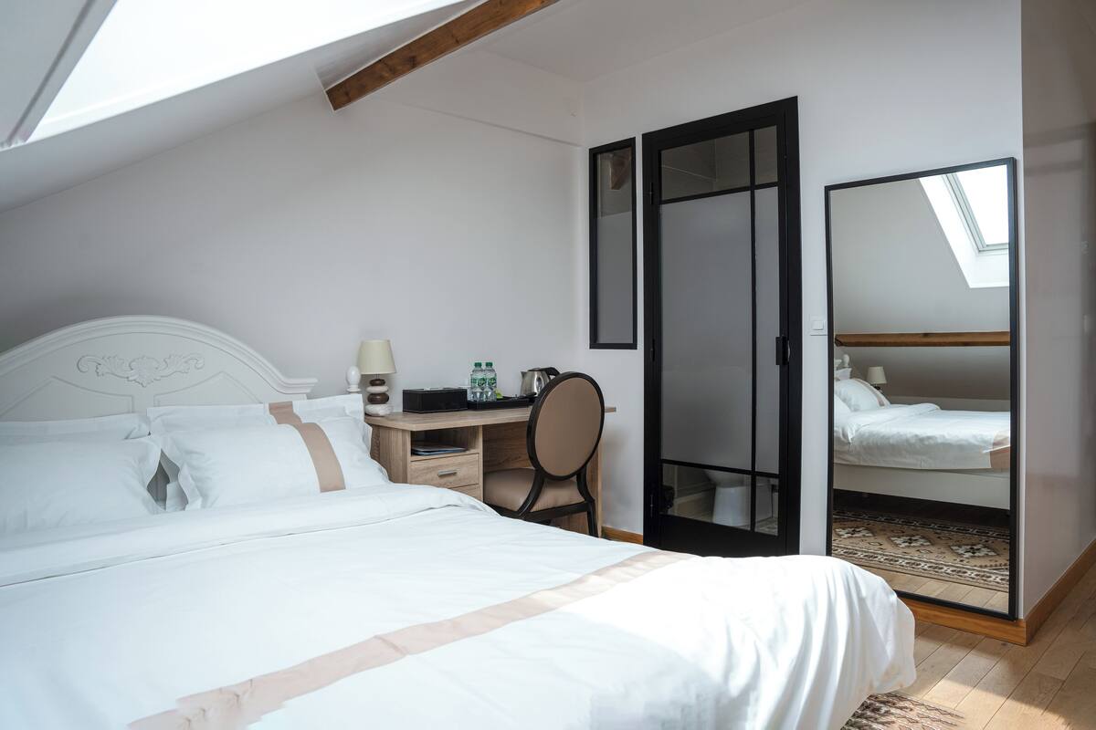 Une chambre à coucher comprenant un lit, un bureau, une chaise et une armoire avec un miroir.