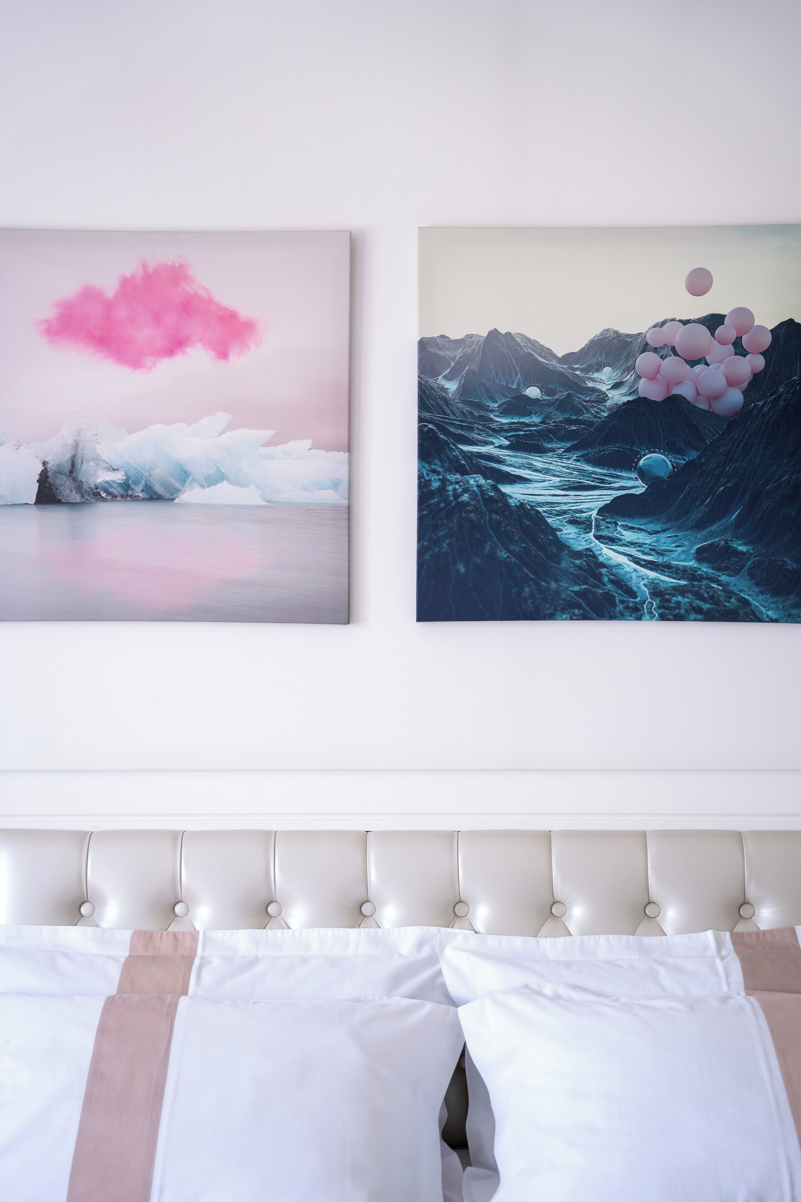 Two wall-mounted artworks depicting icy landscapes and a bed with a tufted headboard.