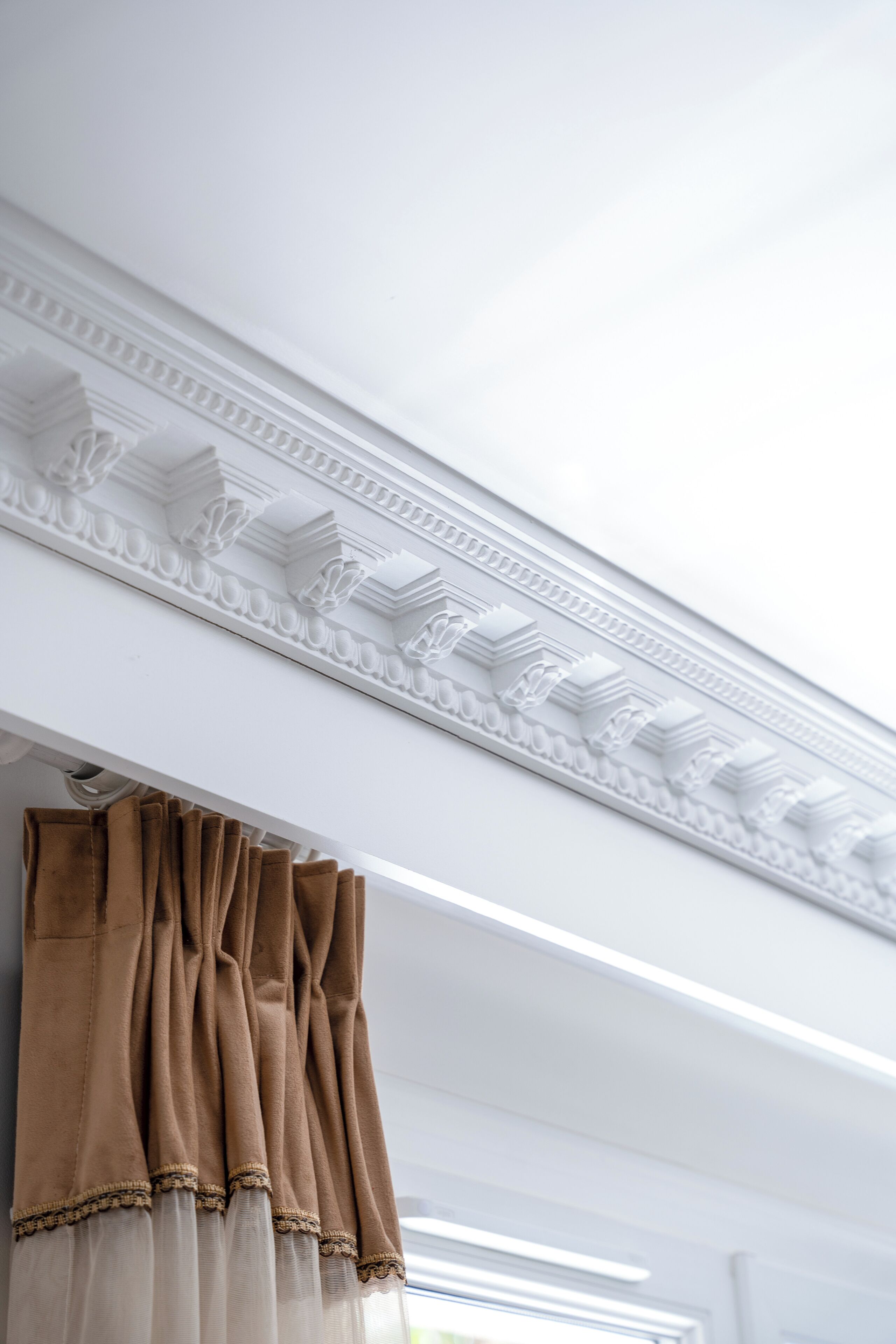 Una habitación con techo blanco y molduras decorativas.
