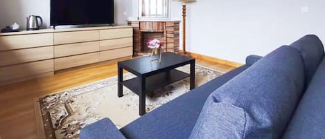Deluxe suite | Woonruimte | Een 100-cm flatscreentelevisie met kabelzenders en een televisie