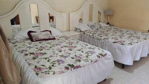 A hotel room with two beds, each with a floral bedspread and white headboards. - Hotel Real Classic Inn (Salcajá)