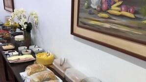 A buffet table with various food items and a painting on the wall.