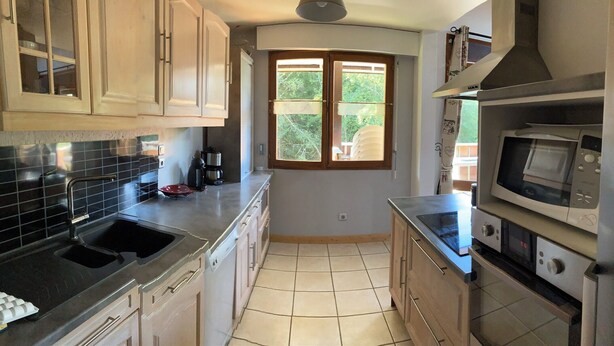 A kitchen with a sink, stove, microwave, and cabinets.