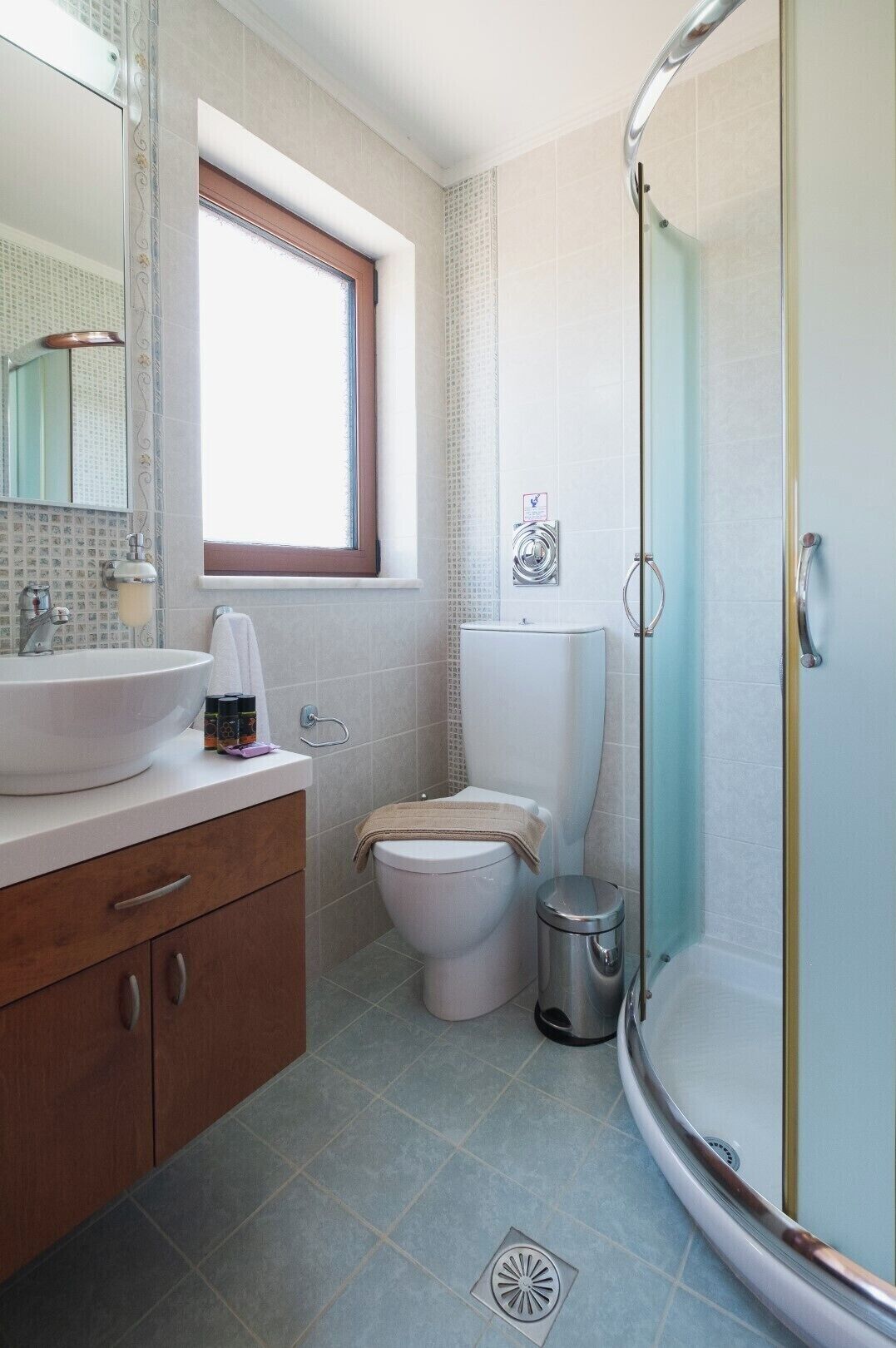 A bathroom with a sink, toilet, and shower.