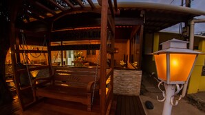 A wooden bench with a view of a building with a sign that reads "HOMES DE NORON". - Pousada da Leide (Fernando de Noronha)