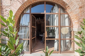 Un edificio de ladrillo con un amplio ventanal de arco y un cartel que indica un hotel de lujo.