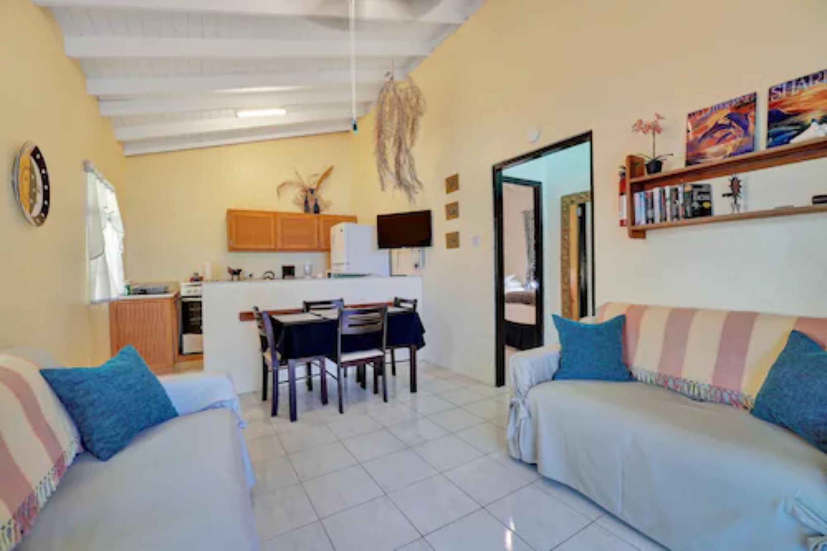 A compact living space with a dining area, kitchenette, and a sofa.