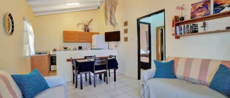 A compact living space with a dining area, kitchenette, and a sofa.