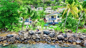 A coastal resort with a rocky shoreline, clear blue water, and lush greenery. - Hideaway Apartments Grenada (St. George's)