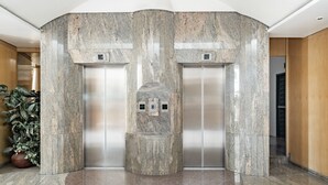 A modern elevator with granite walls and a marble floor in a lobby area. - Capital O Andrade, Mexico City (Mexico City)