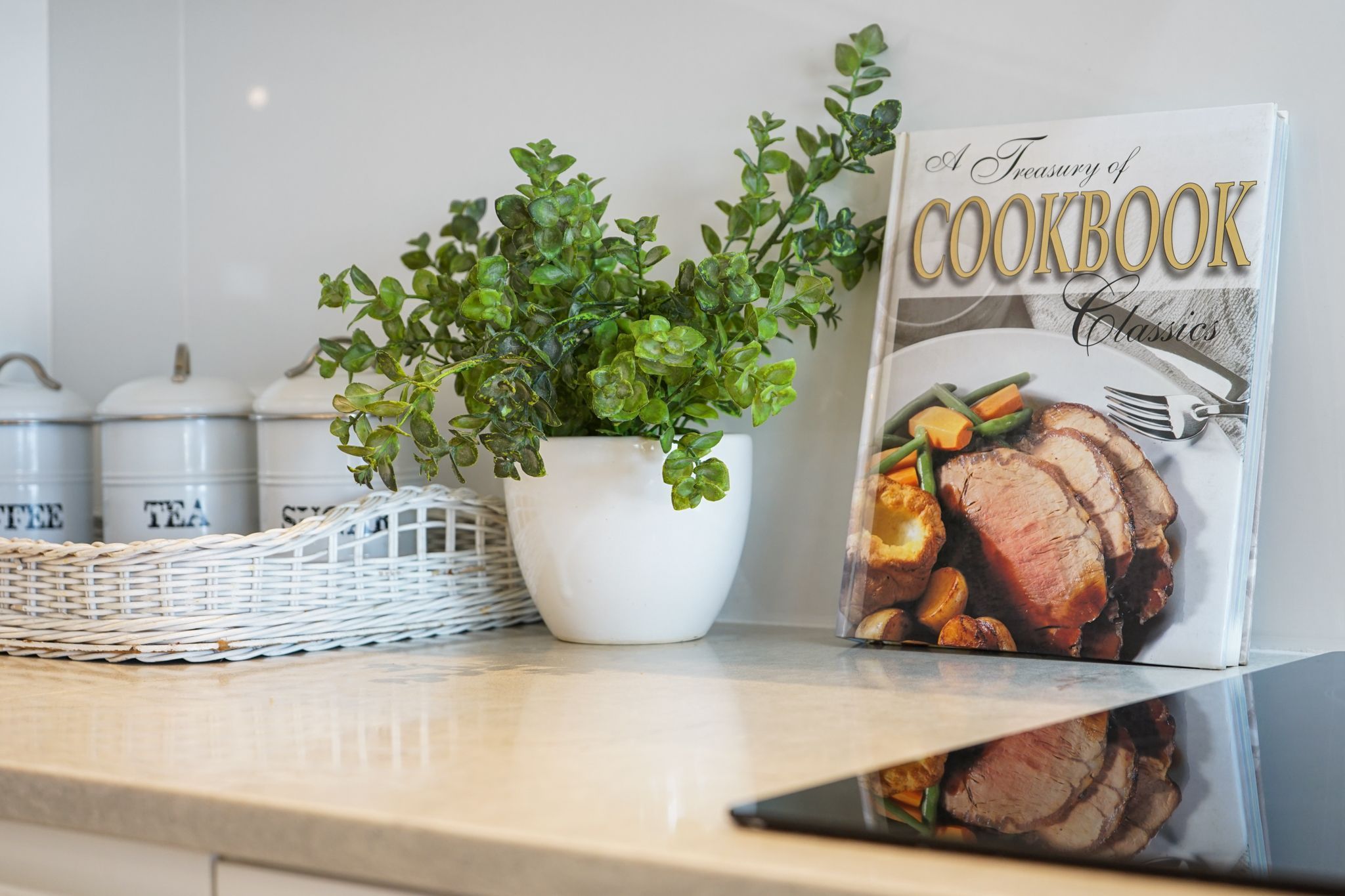 A cookbook titled "A Treasury of Cookbook Classics" on a kitchen counter.