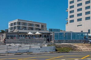 Un immeuble à plusieurs étages qui abrite un restaurant appelé « Doodles Beachfront » au rez-de-chaussée.