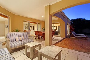Un espace extérieur aménagé avec un patio, un canapé, une table à manger, des chaises et un fauteuil de relaxation.