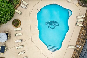 Ein Pool mit Liegestühlen und einem Schild mit der Aufschrift 'Starrcrest Resort'.