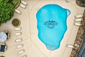 A swimming pool with lounge chairs and a sign reading "Starrcrest Resort".