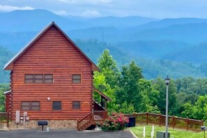 A log cabin with a porch, a mailbox, and a stone foundation. - Finally!  A Cabin Designed with BOTH Kids and Adults in Mind! (Sevierville)