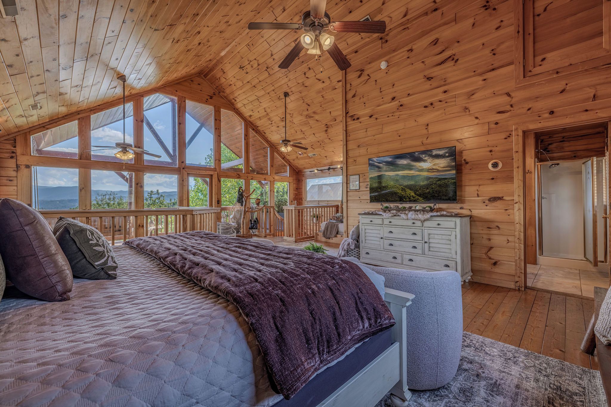 Ein geräumiges Schlafzimmer mit einem großen Bett, einem Schminktisch und Blick ins Freie.