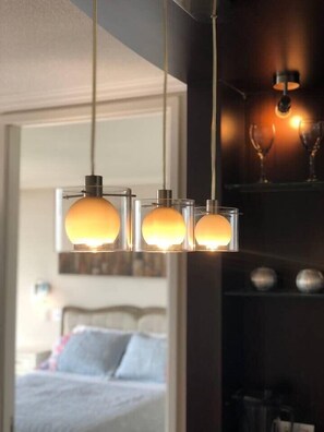A modern hotel room with a bed, a bedside table, and a wall-mounted light fixture. - Kennedy Dream - Indoor Pool, AC, next to Shopping (Vitacura)