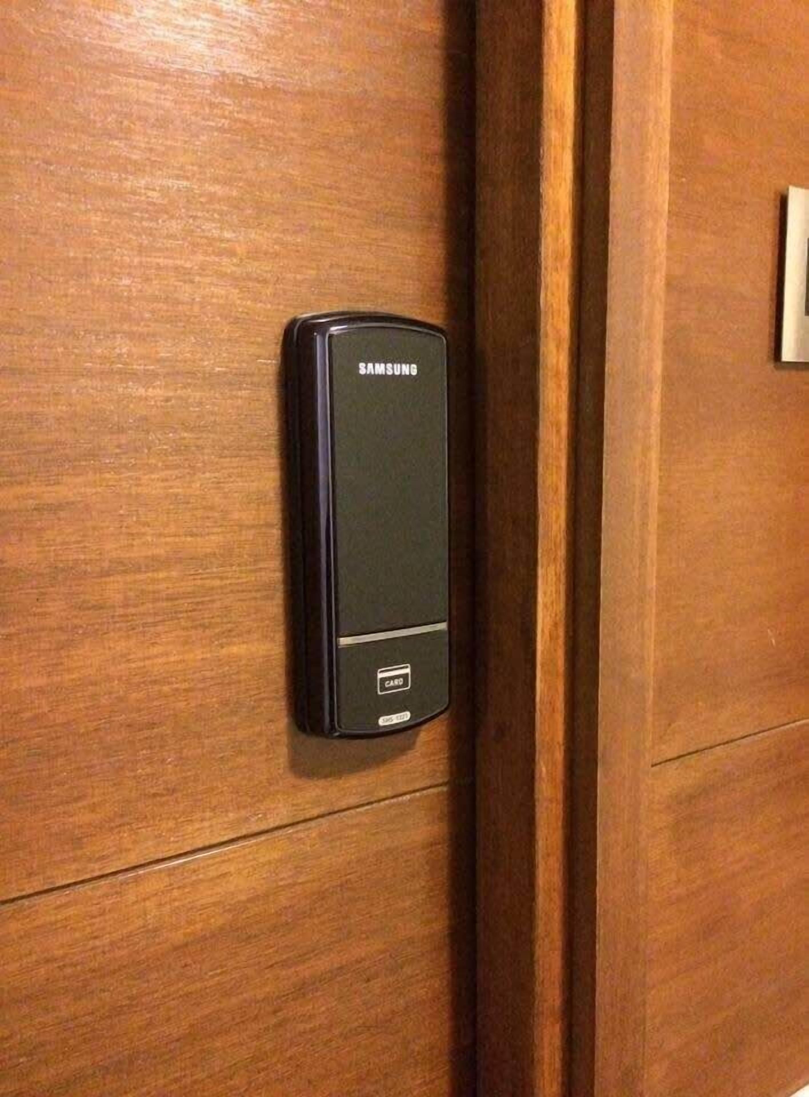 Un lecteur de cartes Samsung fixé sur une porte en bois.