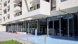 Un bâtiment moderne doté d’une façade en verre et d’un espace piscine.