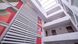 A multi-level interior with white walls, red and green geometric patterns, and balconies with railings. - Bellavista Terrace, BBQ, Parking, AC & City view (Providencia)
