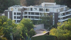A multi-story building with a modern architectural design, featuring balconies and large windows. - Bellavista Spotlight 1BR Apt - w/Parking & A/C (Providencia)