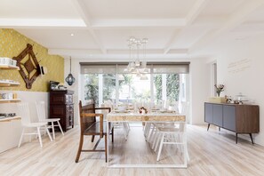 A modern kitchen with a dining area, featuring a large window, wooden chairs, and a marble countertop. - A Home Away From Home (Comuna Chapinero)