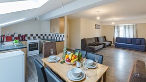 A modern apartment with a dining area, kitchen, and living room. - Kynsparks Luxury Apartments (Birmingham)